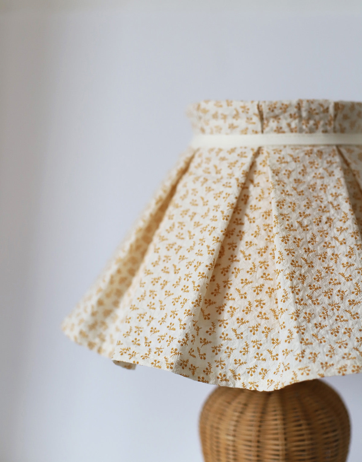Lampe à poser, pied en rotin années '70 et abat-jour plissé amovible