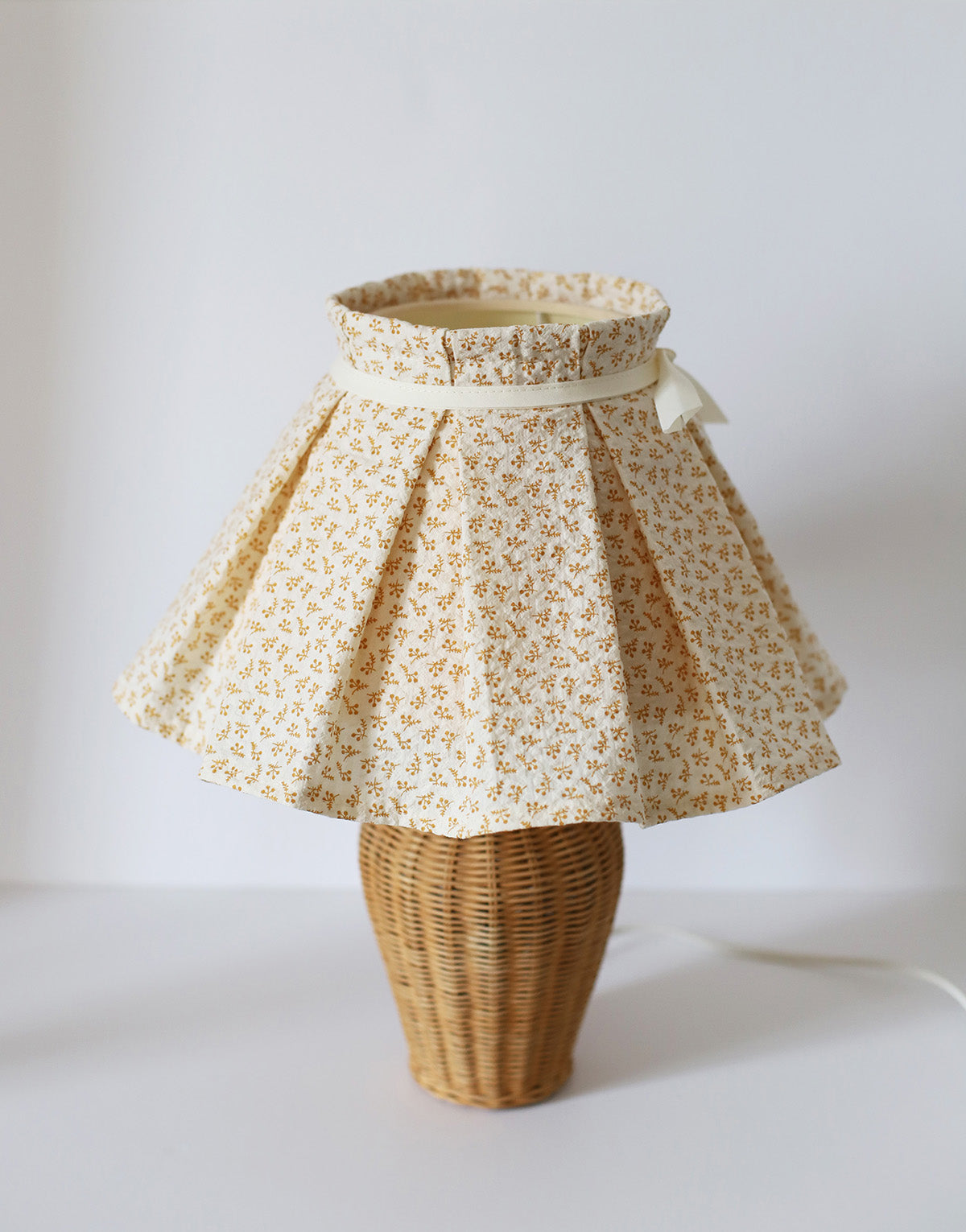 Lampe à poser, pied en rotin années '70 et abat-jour plissé amovible