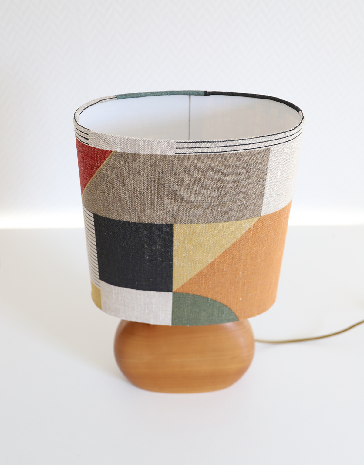 Petite lampe à poser, pied en bois sculpté et abat-jour oval